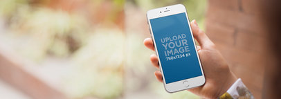 Mockup of a Woman Using Her iPhone 6 at the Garden