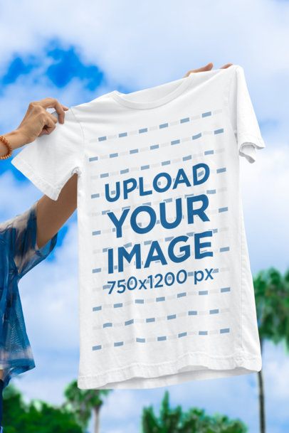 Mockup of a Person Holding a Bella Canvas Round-Neck T-Shirt Against the Sky