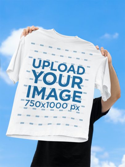 Apparel Mockup Featuring a Man Holding an Oversized T-Shirt Against the Sky