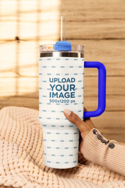 Mockup of a Woman's Hand Holding a Stanley Tumbler in a Cozy Setting