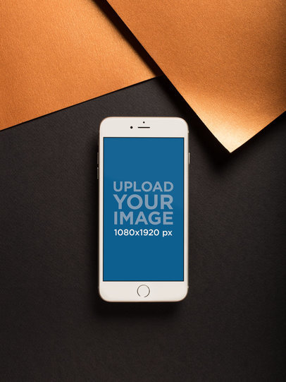 iPhone Mockup on a Black Surface Near Copper Paper Sheets 21492