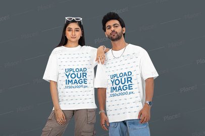Oversized Tee Mockup of a Couple Posing With a Serious Look Against a Customizable Backdrop