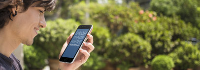 Young Man Using an iPhone 6 Plus Outdoors Featuring Potted Plants Mockup