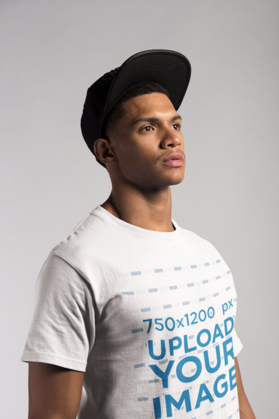 Angled Shot of a T-Shirt Mockup Featuring a Young Man with a Hat