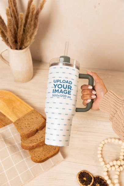 Stanley Tumbler Mockup Featuring a Woman's Hand Against a Table With Bread Slices
