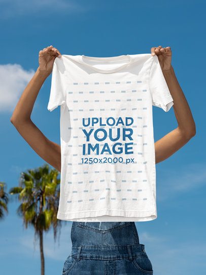 Bella Canvas Mockup of a Woman Holding a Round-Neck T-Shirt Against a Sky With Palms m51756
