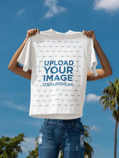Mockup of a Woman Holding an Oversized T-Shirt Against the Sky With Palms