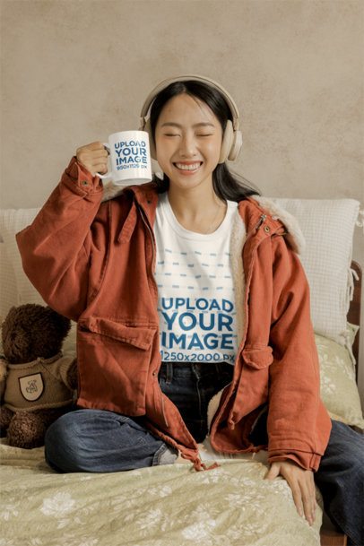 Oversized T-Shirt Mockup of a Happy Woman With a Coffee Mug Posing in a Cozy Bedroom