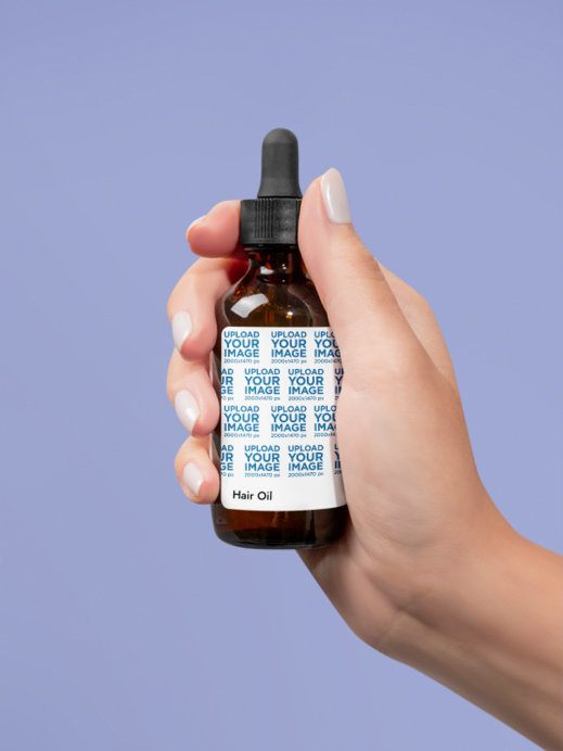 Hair Oil Mockup Featuring a Person's Hand Against a Customizable Background