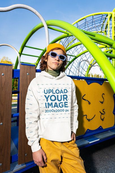 Mockup of a Man Posing in a Playground With a Comfort Colors Hoodie m53360