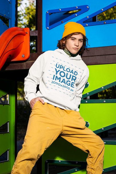 Comfort Colors Pullover Hoodie Mockup Featuring a Man Posing in a Playground Game
