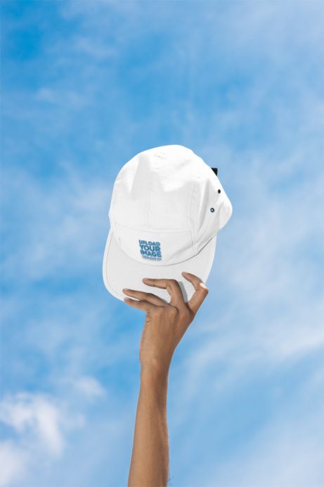 Mockup of a Woman Holding a Yupoong Panel Cap Hat Against the Sky