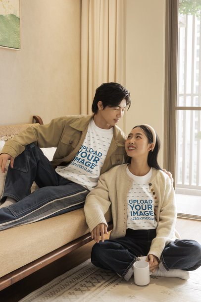 Oversized T-Shirt Mockup of a Romantic Couple Posing Together in a Cozy Living Room