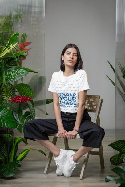 Bella Canvas T-Shirt Mockup Featuring a Woman Sitting on a Chair in a Room With Plants m54672