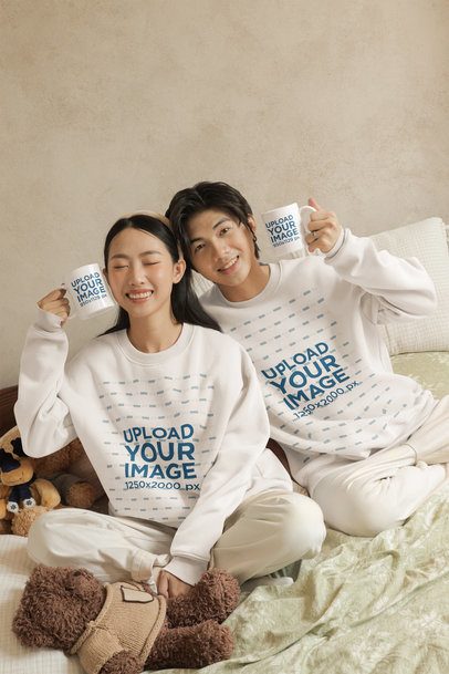 Sweatshirt Mockup of a Happy Couple Holding Coffee Mugs in a Cozy Bedroom