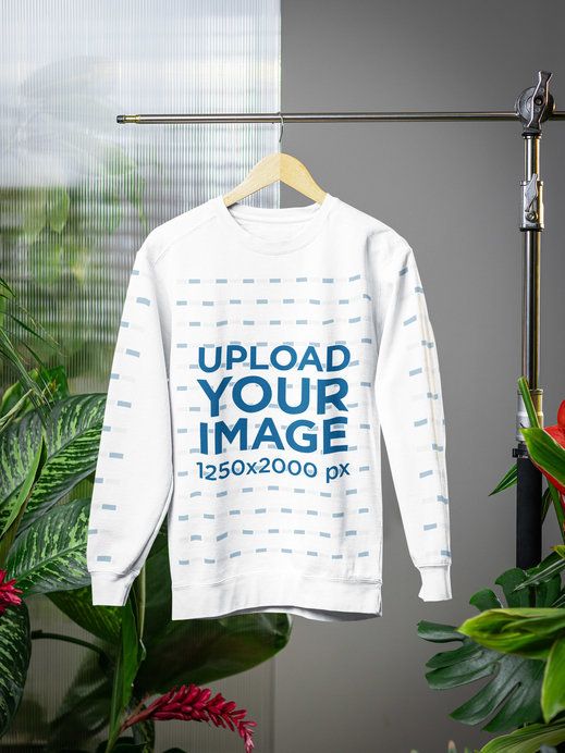 Comfort Colors Sweatshirt Mockup Featuring a Wooden Hanger in a Secret Garden-Inspired Setting