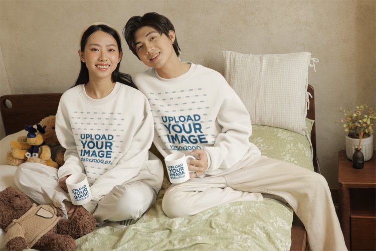Coffee Mug Mockup Featuring a Smiling Man and a Woman Wearing Sweatshirts in a Cozy Room