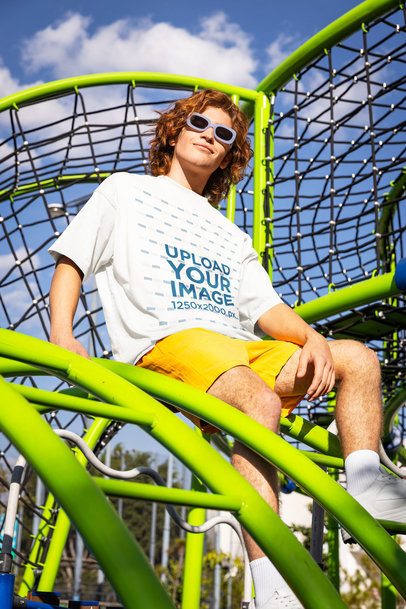 Oversized T-Shirt Mockup Featuring a Man Smiling in a Playground Game