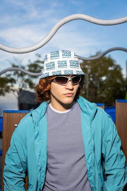 Mockup of a Man Wearing a Sublimated Bucket Hat in a Playground
