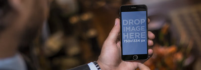 Businessman Using an iPhone 6 While Desending Lobby Staircase