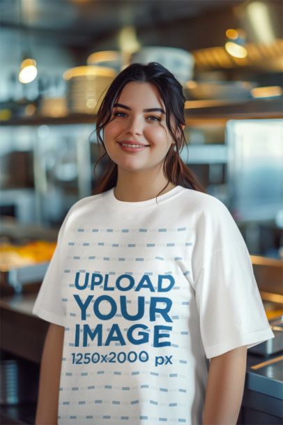 Oversized T-Shirt Mockup of an AI-Generated Smiling Woman Posing in a Restaurant Kitchen