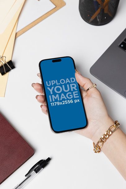 Mockup of a Woman's Hand Holding an iPhone 16 in a Corporate Setting m55715