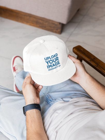 Snapback Hat Mockup Featuring a Man Sitting on a Chair