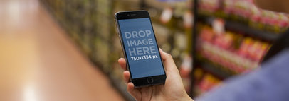 Mockup of a Young Woman Using Her iPhone at the Supermarket