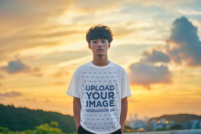 Oversized T-Shirt Mockup of an AI-Generated Man Standing Against a Sunset Sky