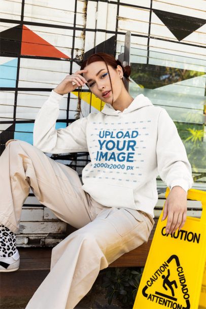 Comfort Colors Hoodie Mockup Featuring a Woman Sitting on the Sidewalk Next to a Caution Sign m55801