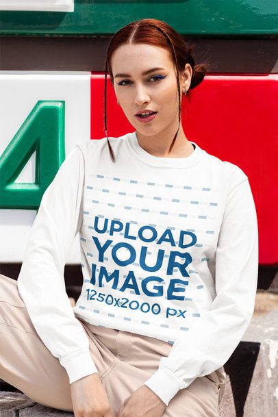 Comfort Colors Long-Sleeve Tee Mockup Featuring a Woman Sitting on a Sidewalk