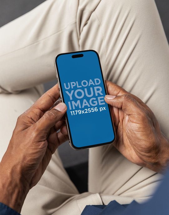 Mockup of a Man Holding an iPhone 16 in a Corporate Setting