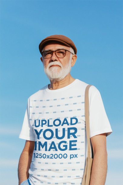 T-Shirt Mockup Featuring an AI-Created Bearded Senior Man Posing Against the Sky