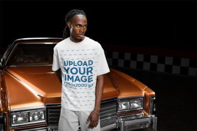 Oversized T-Shirt Mockup of a Serious Man Posing Against a Vintage Car m56273