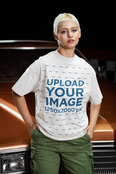 Oversized T-Shirt Mockup of a Serious Woman Posing Against a Car in a Garage m56275