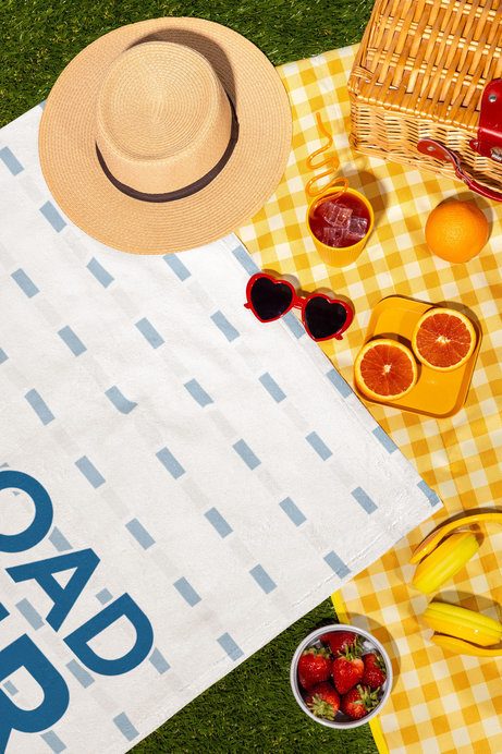 Mockup of a Beach Towel Lying on a Nice Summer Picnic Setting
