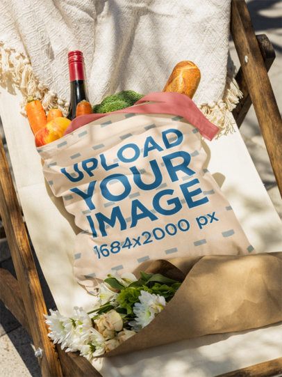 Mockup of a Sublimated Tote Bag Filled With Food Lying on a Chair With a Bouquet m56495