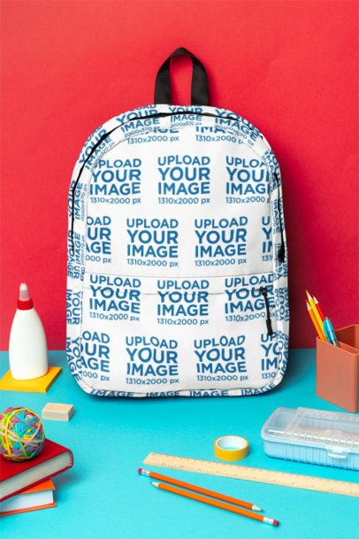Mockup of a Sublimated Backpack Placed on a Surface With School Supplies