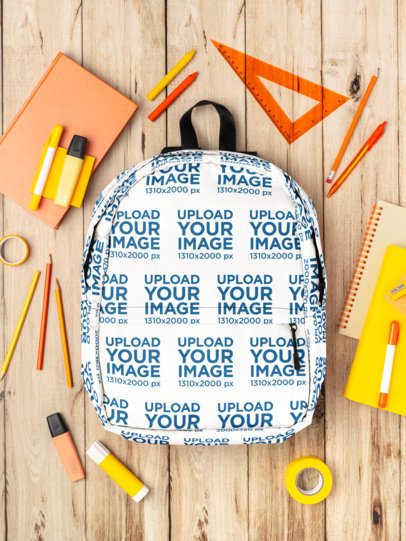 Mockup of a Backpack Placed Over a Wooden Surface and Surrounded by School Supplies