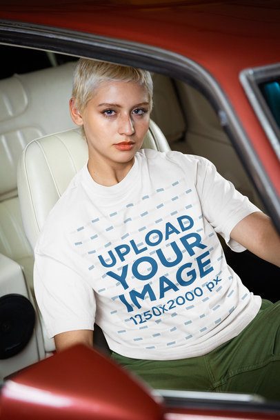 Oversized Tee Mockup Featuring a Serious Woman Posing Inside a Vintage Car m56277