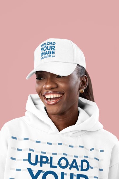 Dad Hat Mockup of a Smiling Woman Wearing a Pullover Hoodie in a Studio