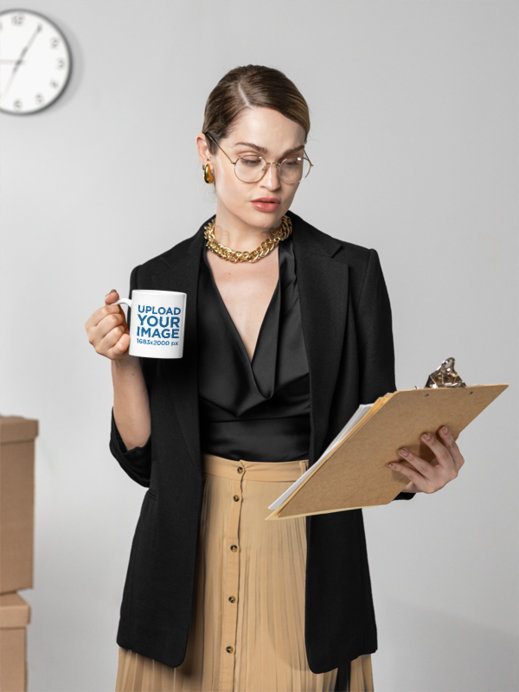 Mockup Featuring a Woman Holding a Coffee Mug While Reading Papers at an Office