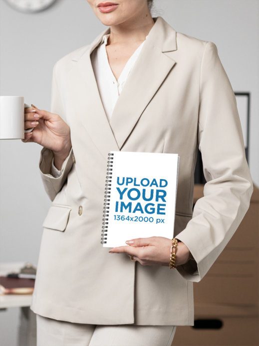 Mockup of a Cropped-Face Woman Holding a Spiral Notebook at an Office