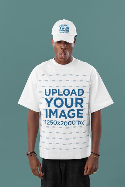 Oversized T-Shirt Mockup Featuring a Funny Man Posing in a Studio With a Dad Hat