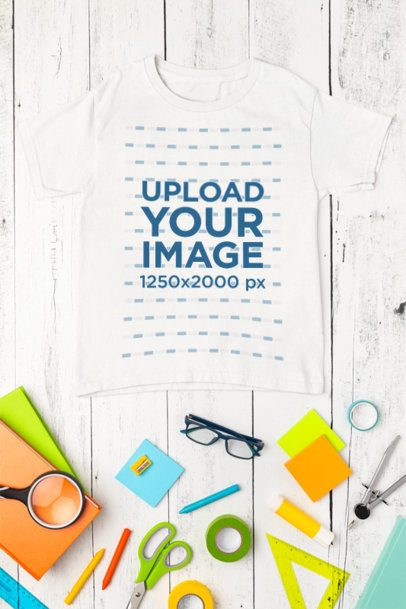 Mockup of a Gildan T-Shirt Lying on a Wooden Surface With School Supplies m56726