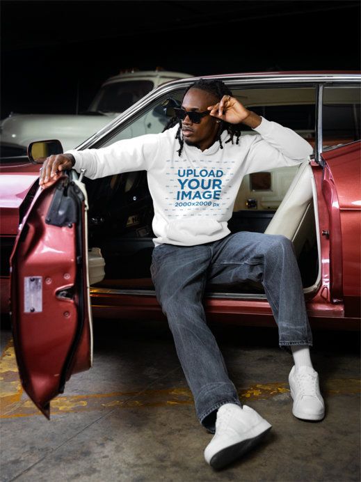 Comfort Colors Hoodie Mockup Featuring a Man Posing on the Driver's Seat of a Vintage Car