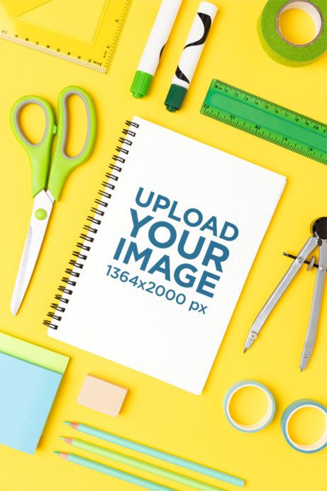 Mockup of a Spiral Notebook Lying on a Colorful Surface and Surrounded by School Stuff