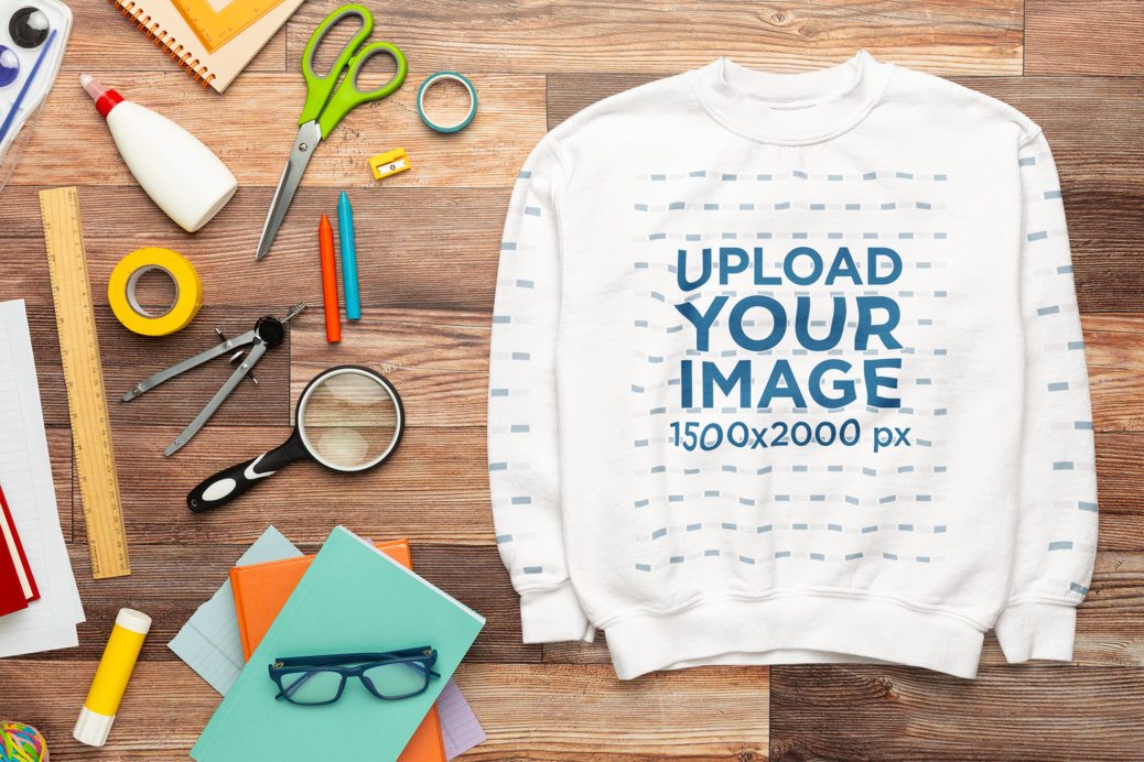 Gildan Mockup of a Sweatshirt Lying on a Wooden Surface With School Supplies