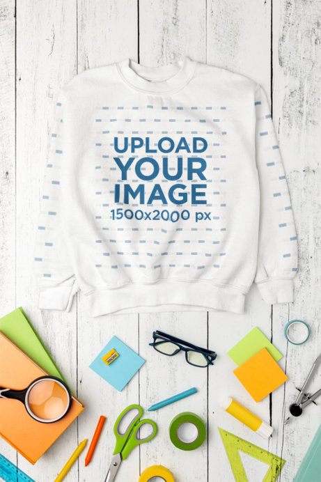 Gildan Mockup Featuring a Sweatshirt With Sleeves Lying on a Wooden Surface With School Stuff