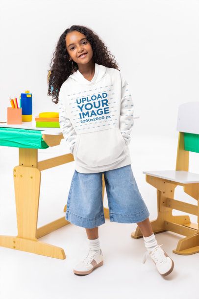 Oversized Hoodie Mockup Featuring a Happy Girl Posing Near a School Desk